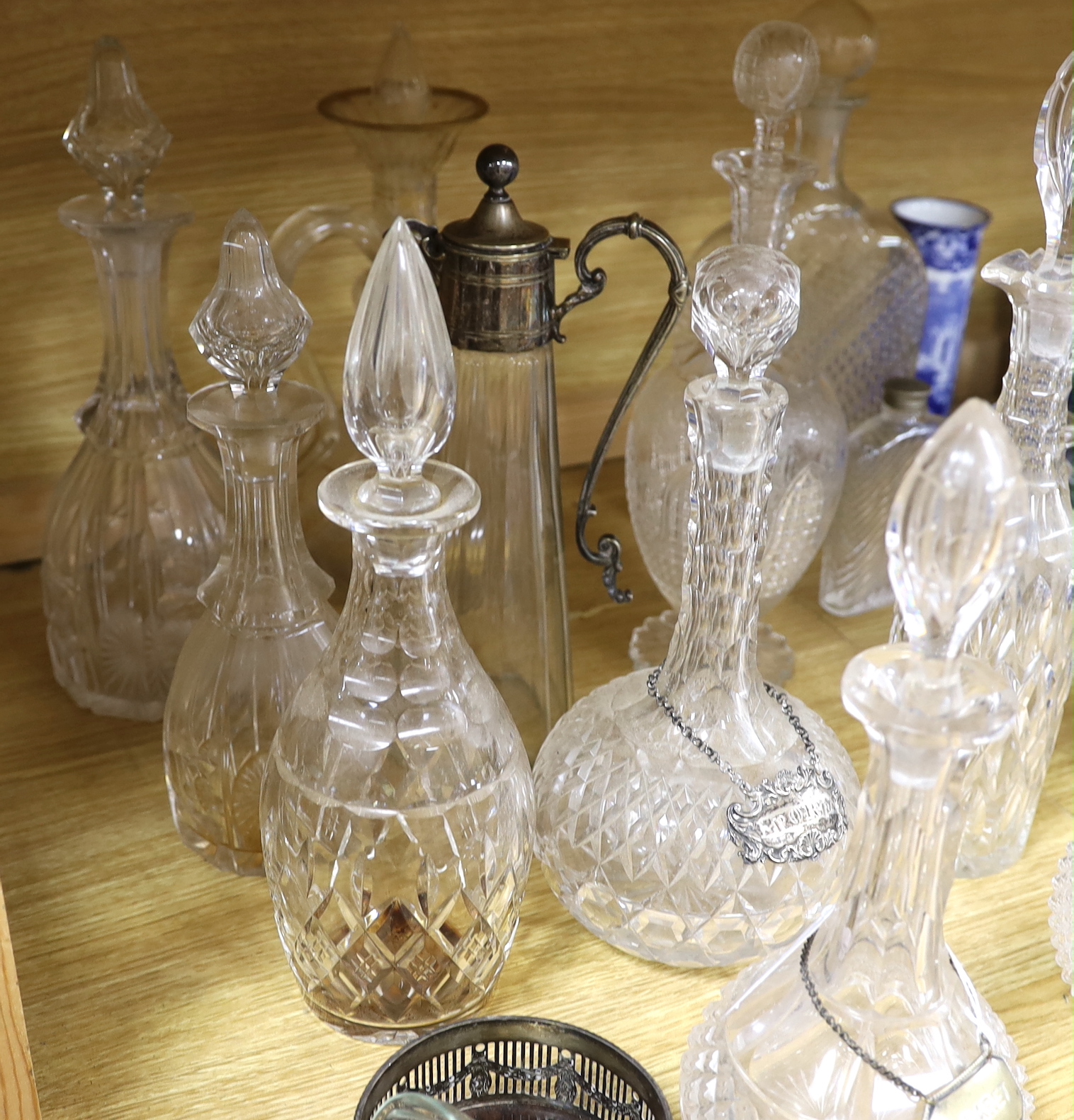 A collection of fourteen Victorian and later glass decanters, a glass funnel, a plated claret jug, coaster and scent bottle, tallest 34cm high